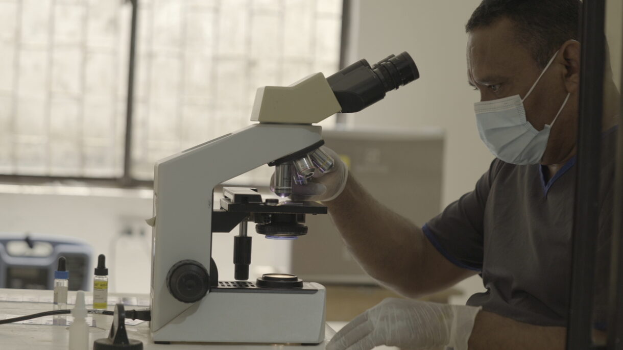 Oscar Tejada, the paramedic and technician in Vector-Borne Diseases, examining malaria test samples
